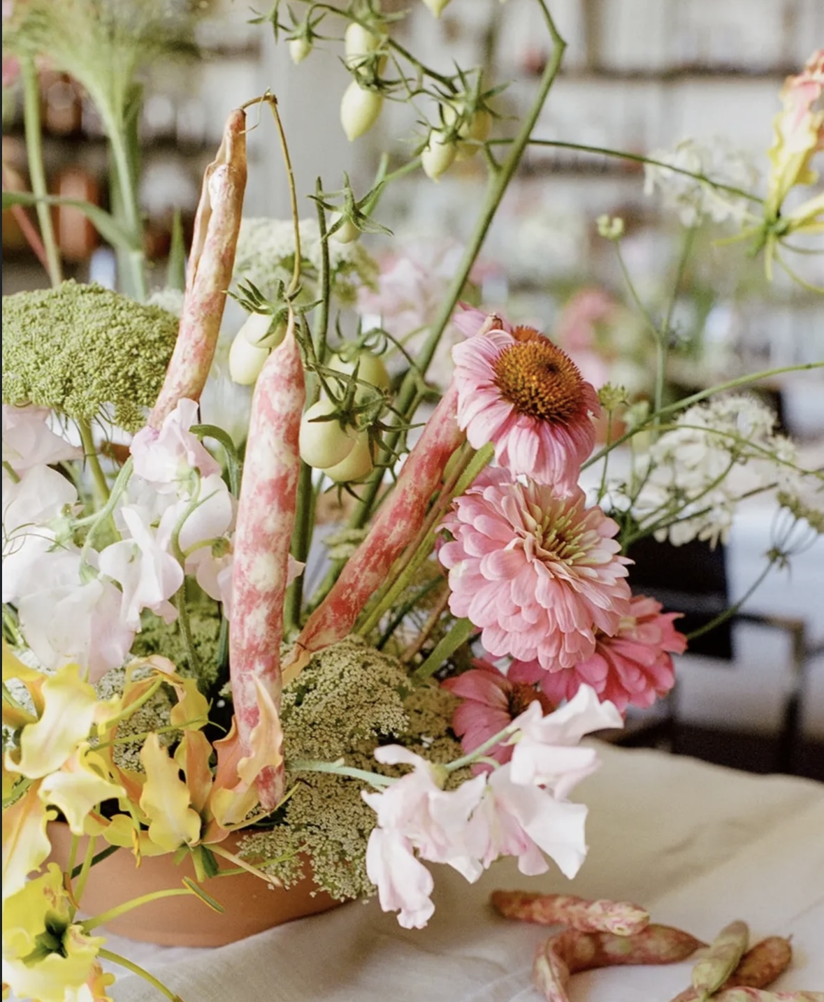Arrangement with pink zinnias, sweet peas, and cranberry bean pods
